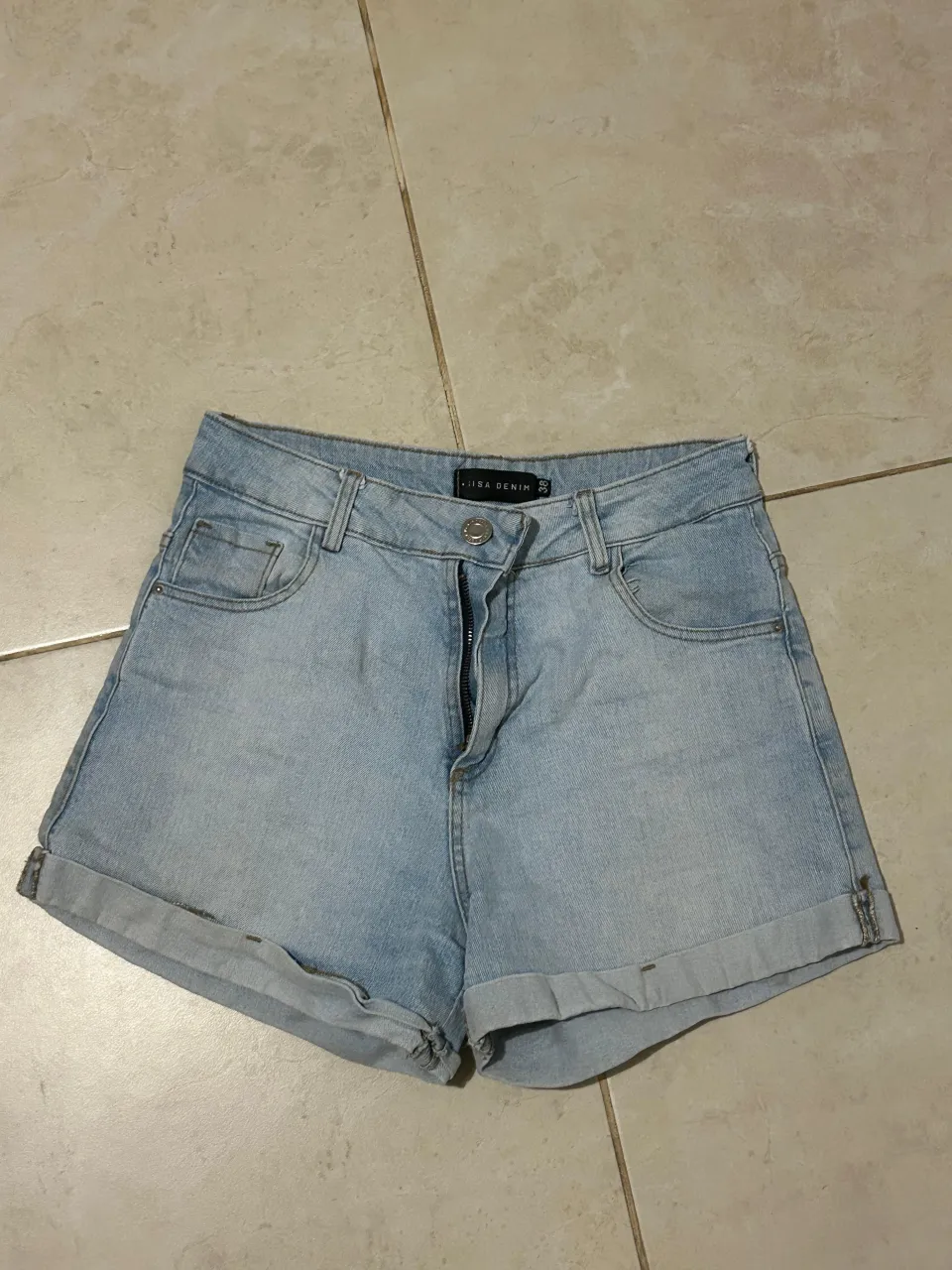 Shorts de jean tiro alto, color celeste claro, con roturas y dobladillos en los bordes. Perfectos para un look casual de verano.