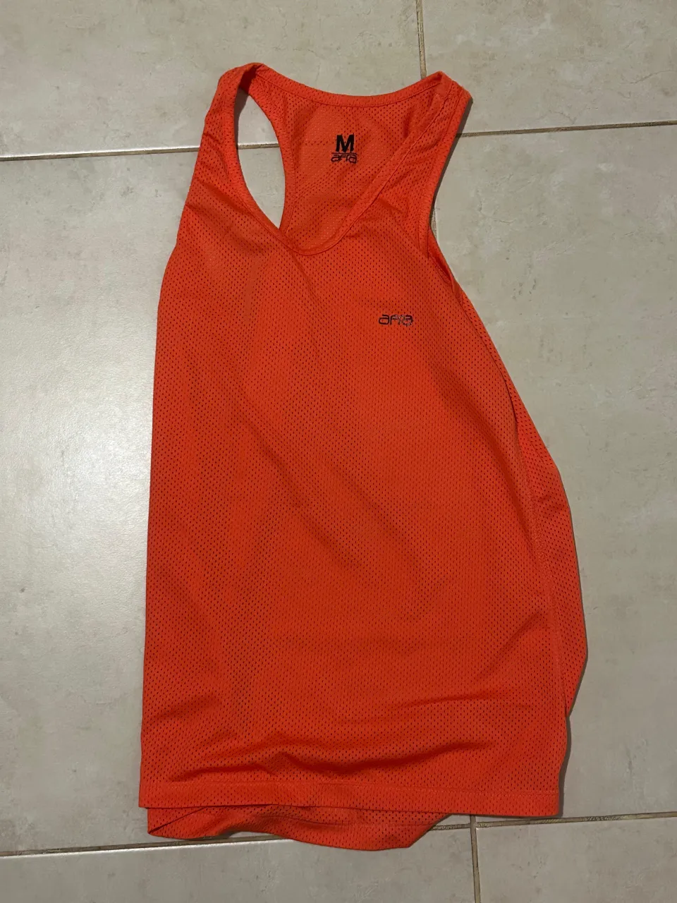 Musculosa deportiva naranja, ideal para entrenamientos intensos. Su diseño permite total libertad de movimiento y transpirabilidad.
