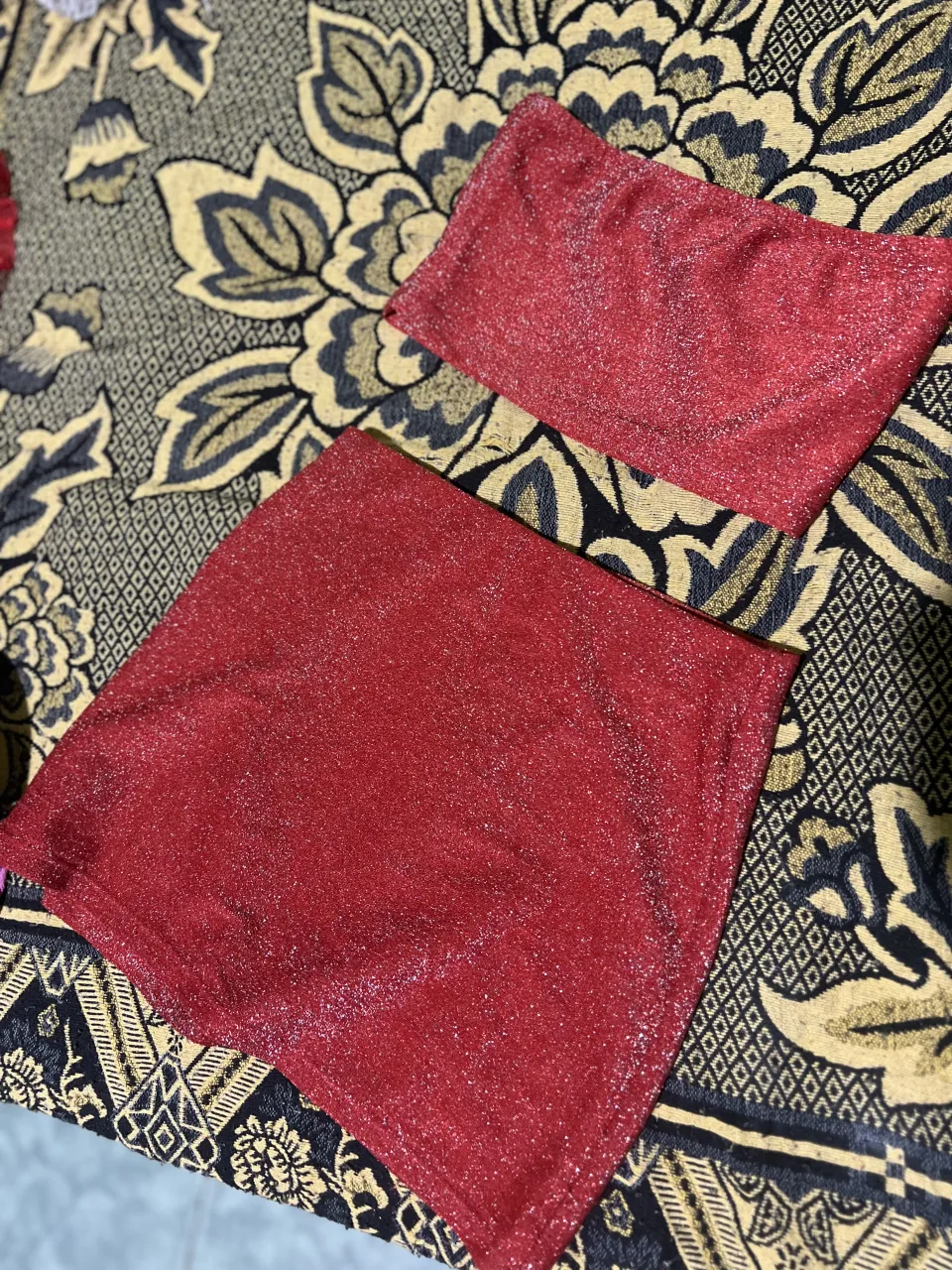 Conjunto de dos piezas, top y pollera, de color rojo con brillos.