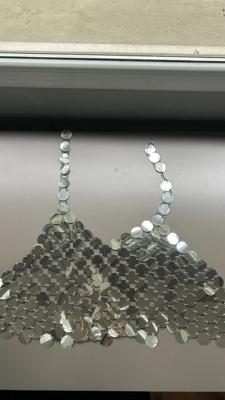 Top de cadenas plateadas con discos circulares.