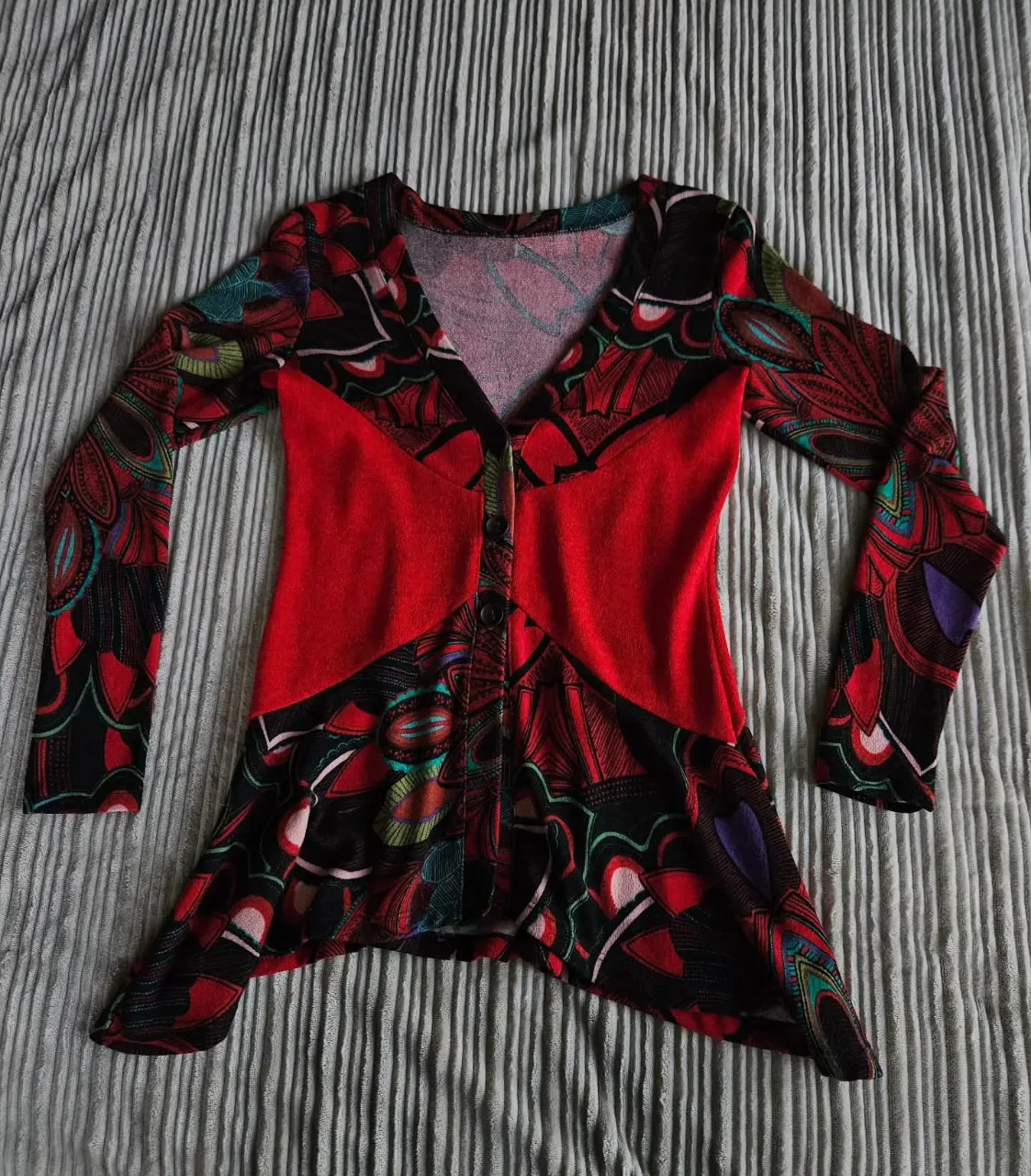 Saco de lanilla manga larga con estampa psicodélica y detalles en rojo. Posee cuello en V y botones al frente. Entallado.