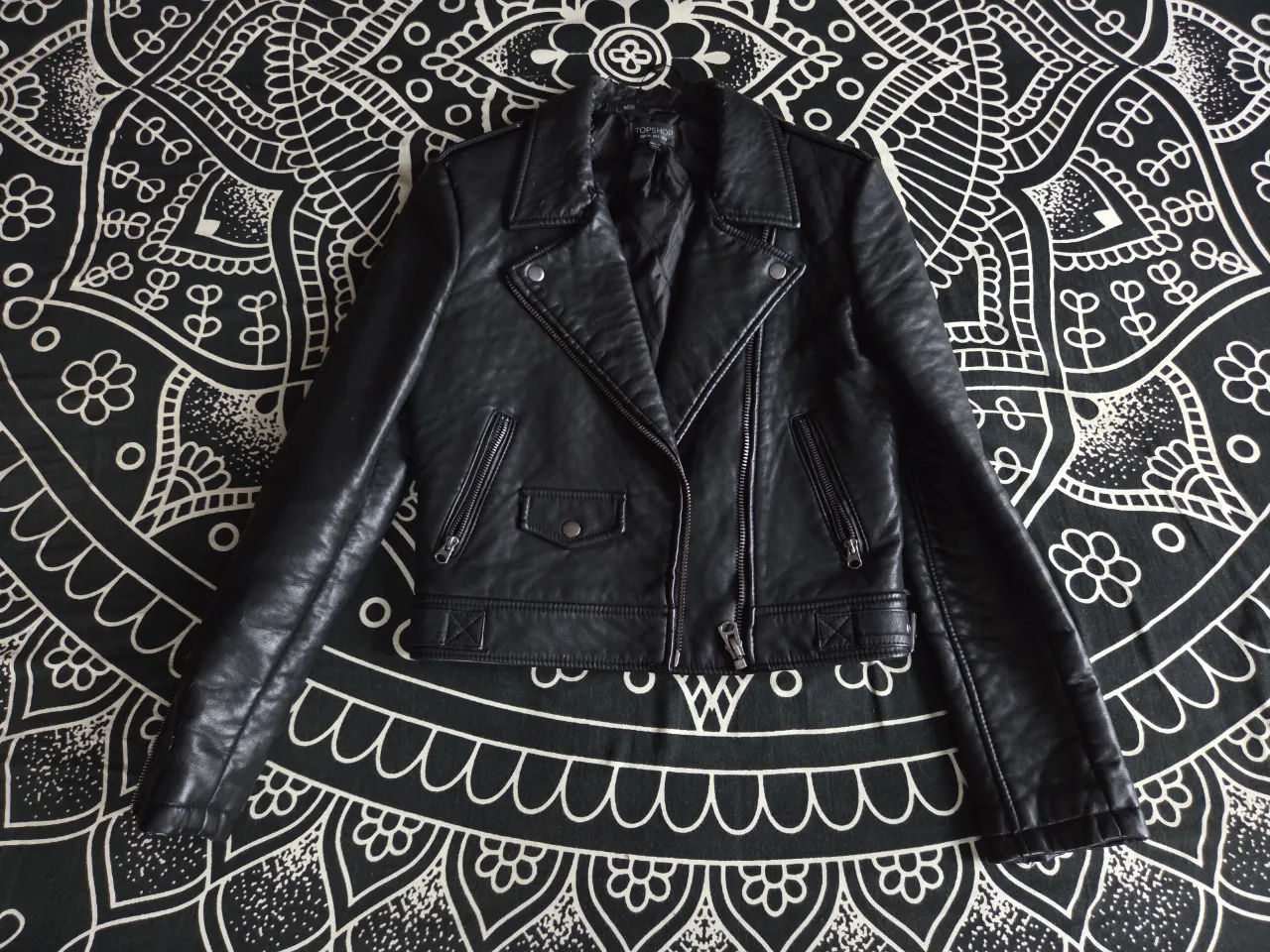 Campera de ecocuero negra, estilo biker, con cuello solapa, cierre al frente y bolsillos con cierre. Presenta detalles de desgaste en el cuello y la espalda. Super abrigada.