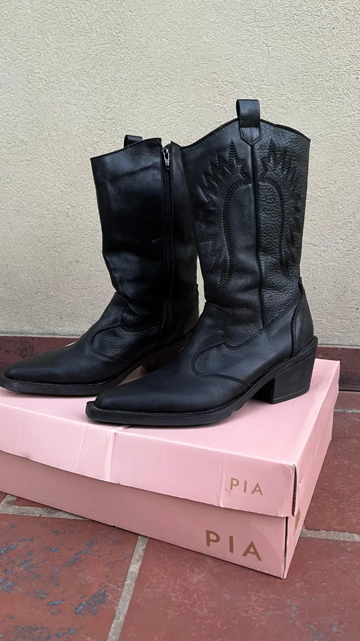 Botas de cuero negras, con caña alta. Tienen un solo uso literal.